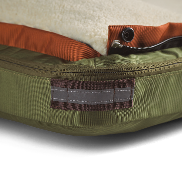 Close up showing detail of the teak brown corner reflective accent and loop on small green dog bed for travel, home, office, or on the road, best dog beds for small dogs, dog beds for large dogs